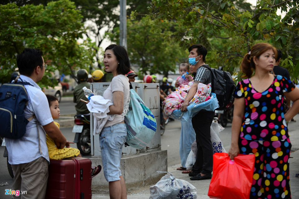 Người dân tay xách nách mang chăn, gối, quần áo... để đón xe đi tìm chỗ ở.