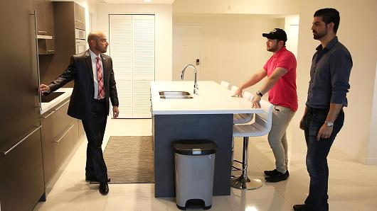 Chuyên gia môi giới (bên trái) với người mua thăm quan một ngôi nhà ở hạt Doral, bang Florida, Mỹ